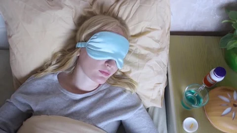 A woman cannot fall asleep and wants to drink a capsule with melatonin, a sleepi Stock Footage 287705296