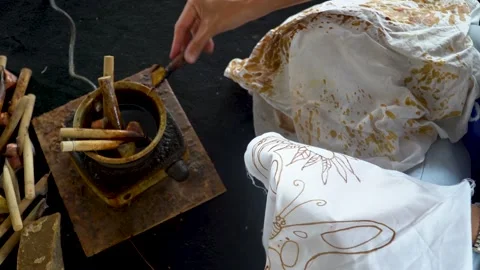 Woman canting to create unique batik motif on fabric using melted wax, Stock Footage 148309720