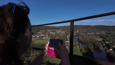 Woman capturing a panoramic view of a valley with her smartphone Stock Footage 293868519