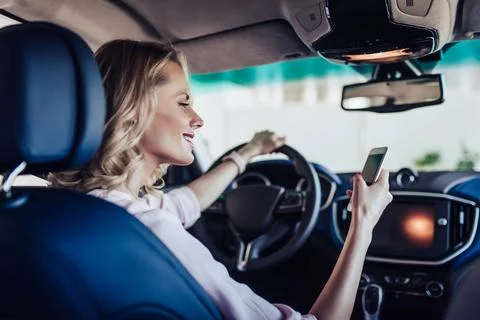 Woman in the car using smartphone Stock Photos