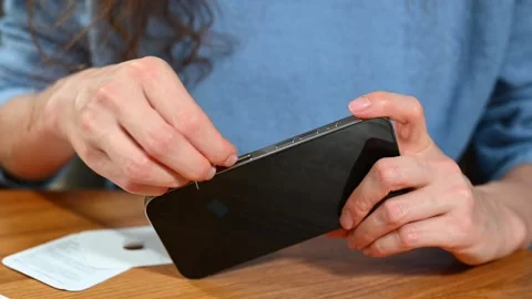 Woman is carefully ejecting sim-card slot from new Apple Iphone 스톡 동영상 286355544