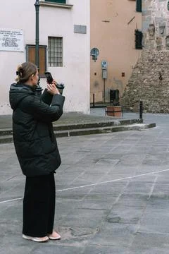 A woman carefully frames a shot with her camera Stock Photos