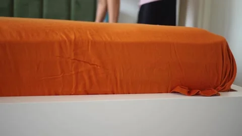 Woman carefully placing a fitted bedsheet on a comfortable mattress in a mo.. Stock Footage 332194673
