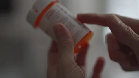 Woman Carefully Reading Instruction Leaflet While Holding Prescription Pill.. Stock Footage 321009341