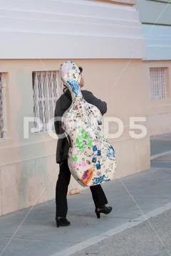 Woman carrying cello Stock Photos
