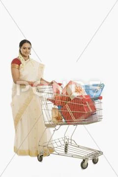 Woman carrying gifts in a shopping cart Stock Photos