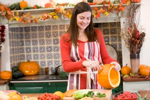 Woman carving jack o lantern on Halloween and smiling Stock Photos