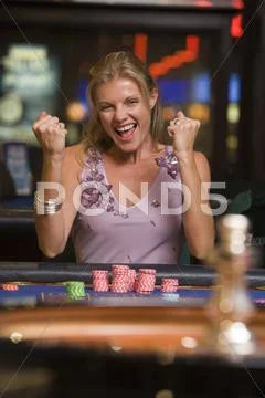 Woman in casino winning roulette smiling (selective focus) Stock Photos