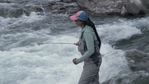 Woman casting fishing line into fast flo, Stock Video
