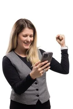Woman celebrating while using a smartphone at a plain background during daytime Stock Photos