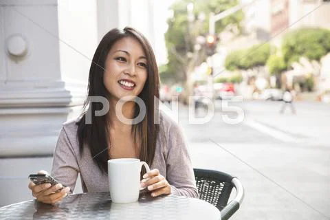 Young woman using public telephone