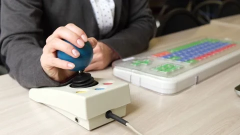 Woman with cerebral palsy works on a specialized computer mouse. Stock Footage