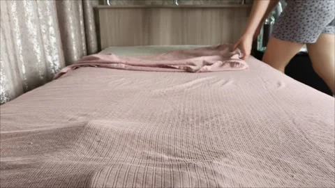 A woman changes the bed linen on the bed in the room. Stock Footage 311653681