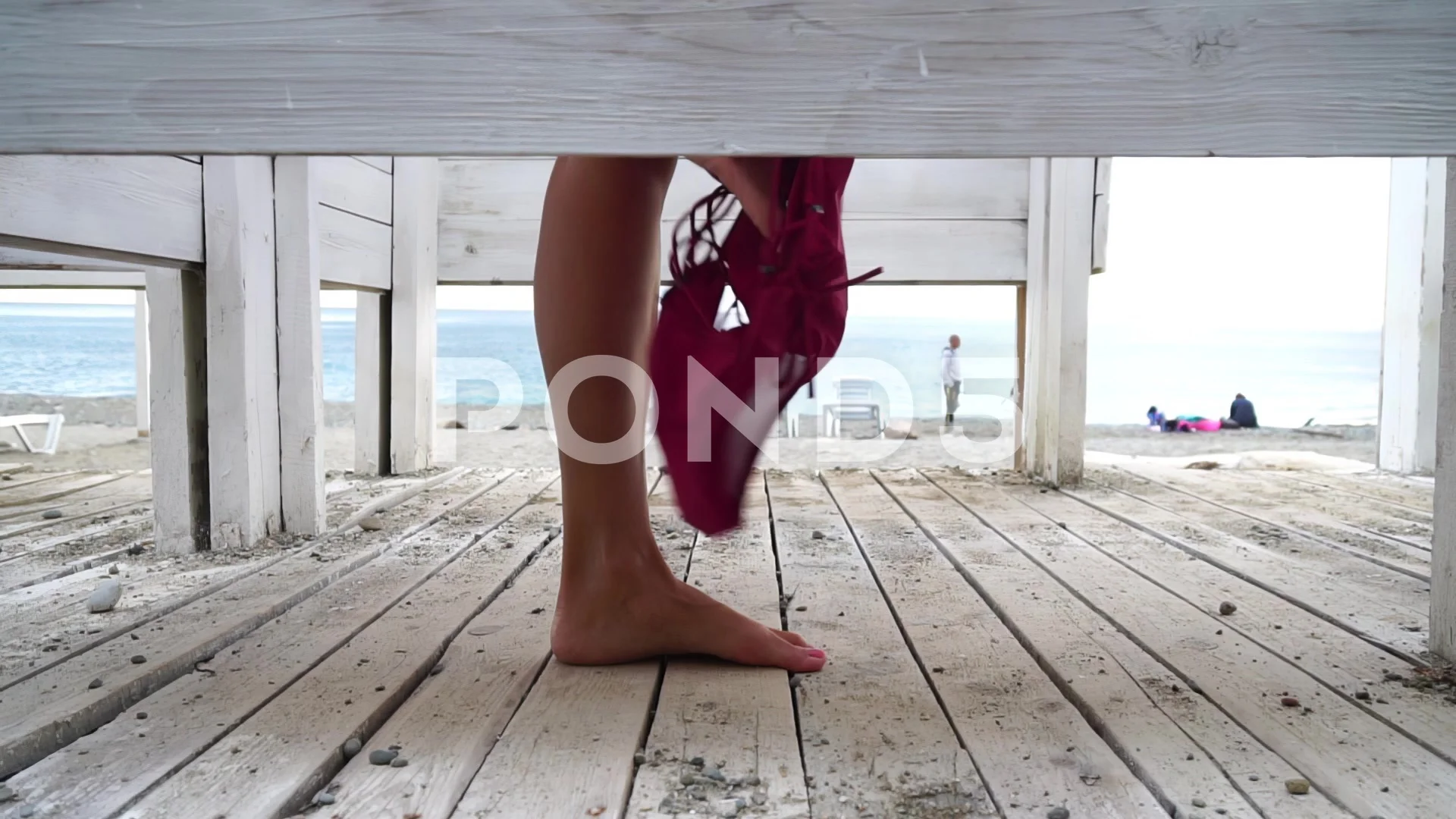 Woman in the changing, dressing room on the beach, at sunset on the seashore