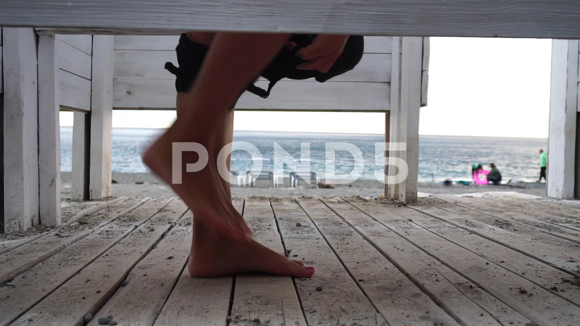 Woman in the changing, dressing room on the beach, at sunset on the seashore