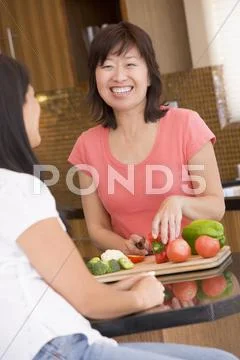 Woman chatting to friend while preparing meal,mealtime Stock Photos