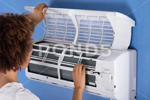 Woman Checking Air Conditioner At Home Stock Photos