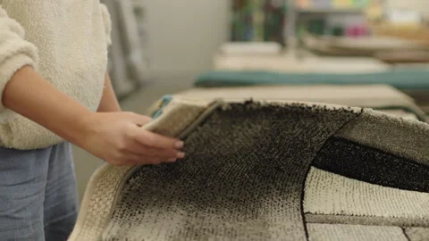 Woman checking carpet quality and texture in home furnishing store Stock Footage 334580088