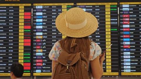 Woman checking flight schedule board in airport terminal Vídeos de archivo 335468698