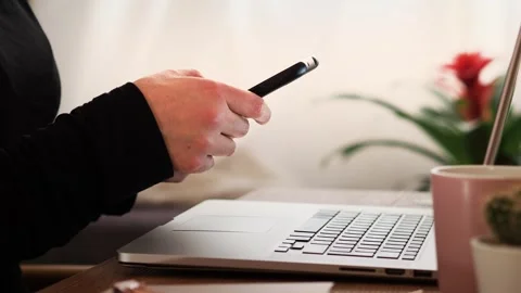 Woman checking her mobile phone in front of her computer in the office. Stock Footage 244046819