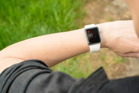 Woman checking her pulse using the Apple Watch Stock Photos