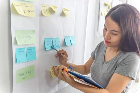 Woman checking information in sticky notes Stock Photos