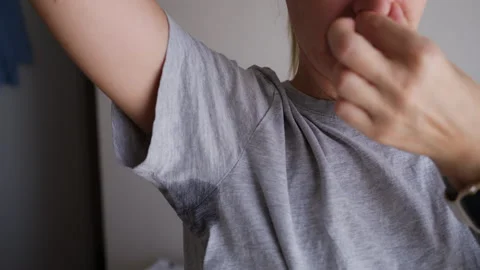 Woman checking a large sweat stain on her gray T-shirt after sweating heavi.. Vidéo 342442835