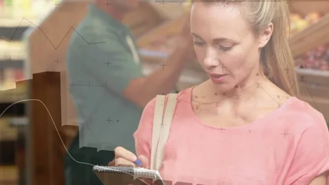 Woman checking spiral notepad with blue pen, writing list in grocery aisle, Stock Footage 321377967