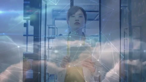 Woman checking tablet in tech corridor, tapping to show cloud network overlay Stock Footage 329786171