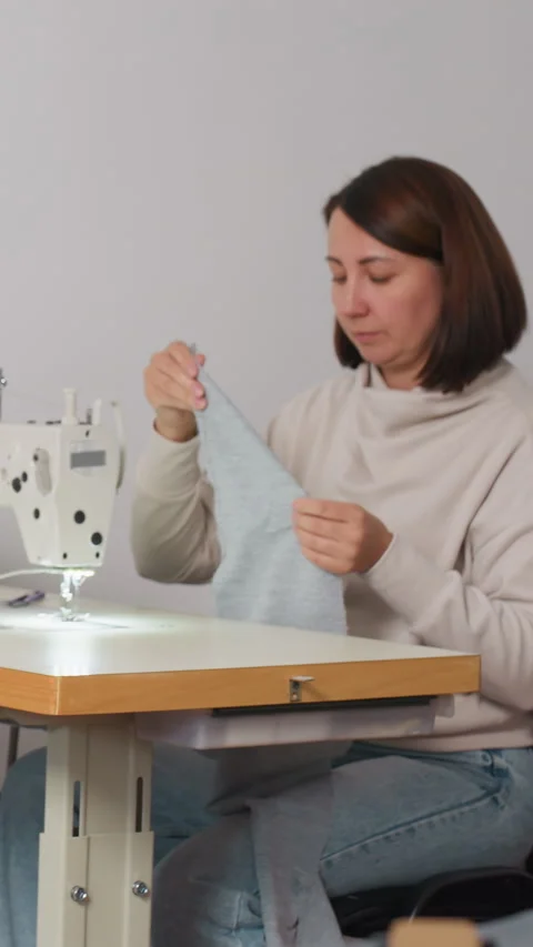 Woman checking textile quality carefully, Female inspecting knitted material Stock Footage 326928734