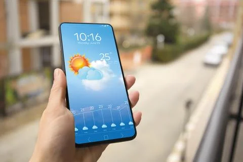 Woman checking weather using app on smartphone outdoors, closeup. Data and .. Foto stock