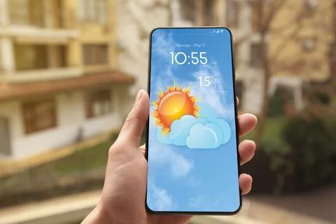 Woman checking weather using app on smartphone outdoors, closeup. Data and .. Stock Photos