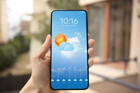 Woman checking weather using app on smartphone outdoors, closeup. Data and .. Stock Photos