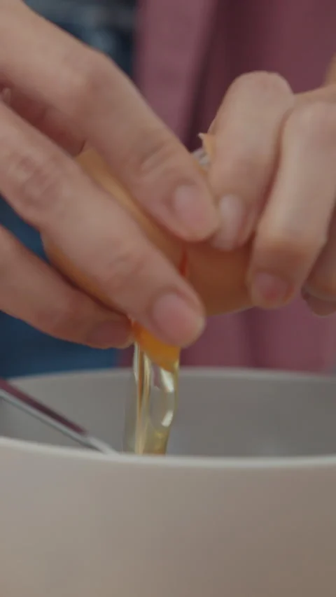 Woman chef cracking eggs into ceramic bowl cooking omelette with vegetables. Stock Footage 335993620