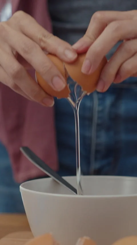 Woman chef cracking eggs into ceramic bowl cooking omelette with vegetables. Stock-Footage 335995941