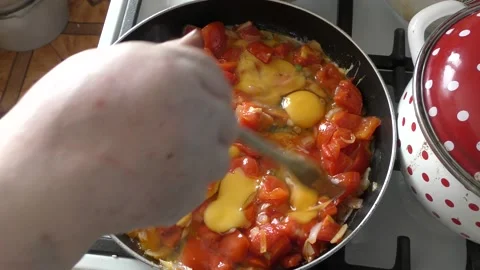 Woman chef fries scrambled eggs with vegetables Stock Footage 163544853