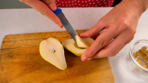 Woman chef hands removing core from half pear on cutting board cooking dessert. Stock Footage 313000652