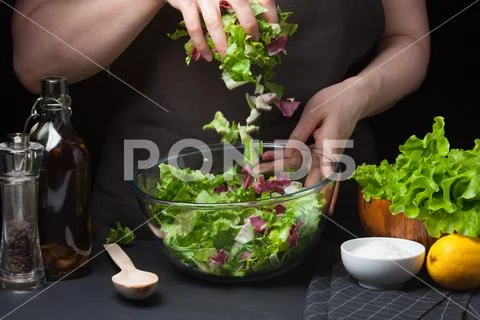 Woman chef in the kitchen cooking vegetable salad. Healthy Eating. Diet Concept Stock Photos