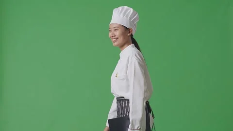 Woman Chef Taking Note On A Tablet While Walking In The Green Screen Background Stock Footage 249623160