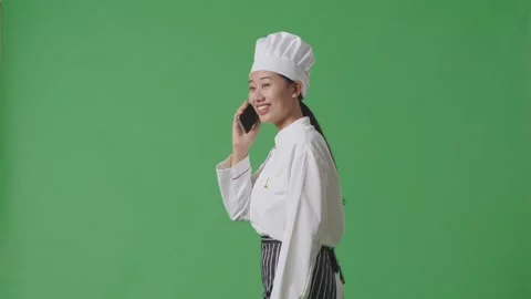Woman Chef Talking On Smartphone While Walking In The Green Screen Background Stock Footage 249623113