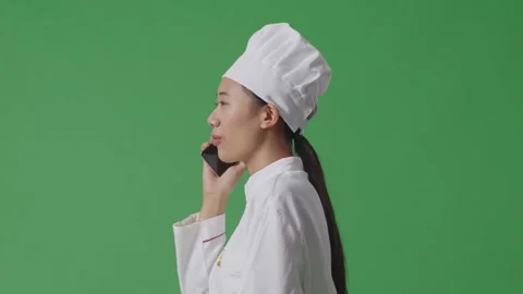 Woman Chef Talking On Smartphone While Walking In The Green Screen Background Stock Footage 249623327