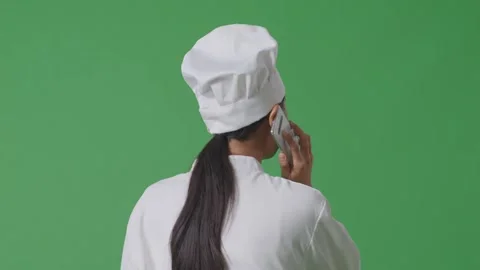 Woman Chef Talking On Smartphone While Walking In The Green Screen Stock Footage 249623491