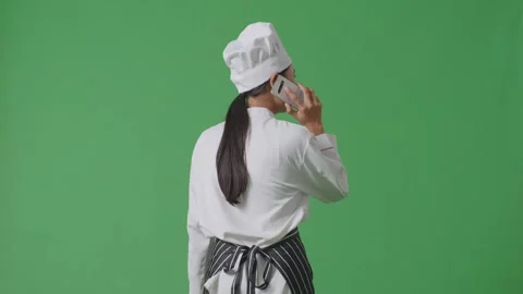 Woman Chef Talking On Smartphone While Walking In The Green Screen Background Stock Footage 249623579