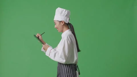 Woman Chef Using A Tablet While Walking In The Green Screen Background Studio Stock Footage 249623147