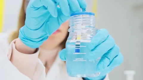 Woman chemist tests solution for the pH using indicator paper Stockbeeldmateriaal 245090874
