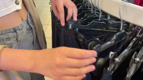 A woman chooses clothes on a rack in a store, 스톡 동영상 238819832