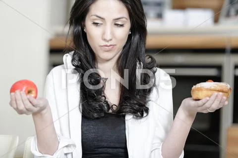 Woman choosing cake or fruit Stock Photos
