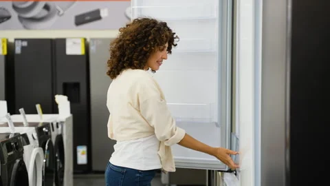 Woman choosing refrigerator in electronics store Stock Footage 317733636