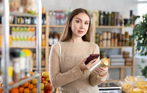 Woman choosing scanning QR code on can of beer in grocery shop Stock-Fotos