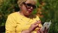 Woman with cigarette sits on the bench and uses white smartphone HD Footage